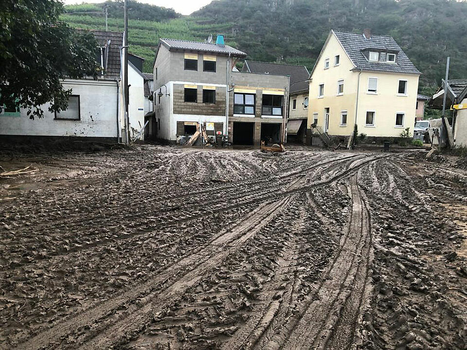 Die Straßen und Wege sind mit einer braunen Schlammmasse bedeckt, die das Hochwasser hinterlassen hat. (Foto: Bayerisches Rotes Kreuz)